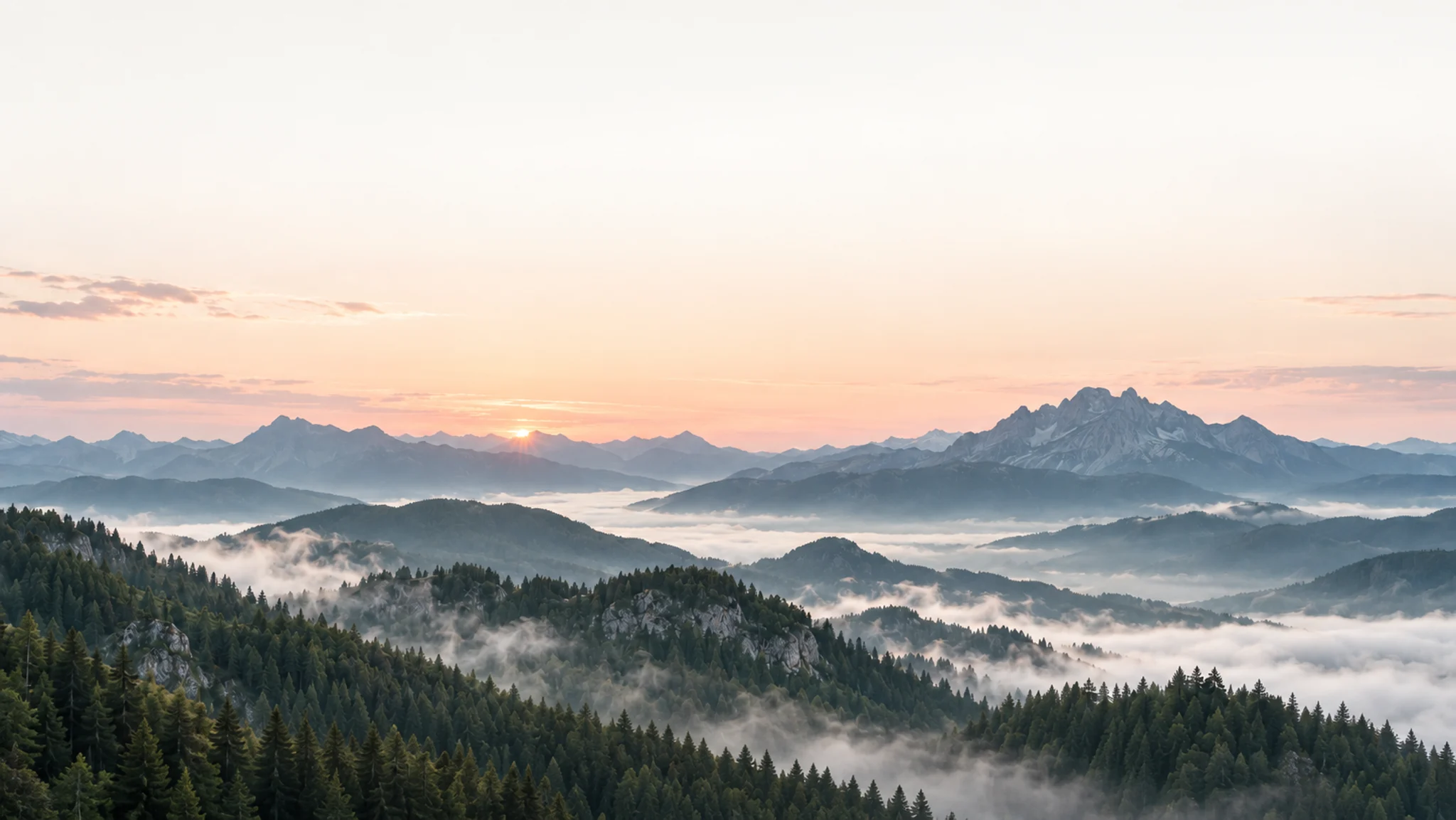 Forested mountain ranges in the morning light, with broad mist-filled valleys between them.